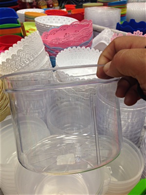 A hand holding a plastic ice bucket