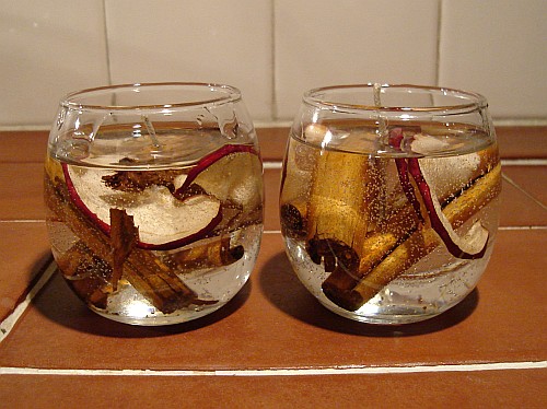 Scented gel candles with dried apple slices and cinnamon sticks.