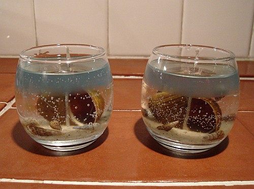 Scented gel candles with shells and sand.