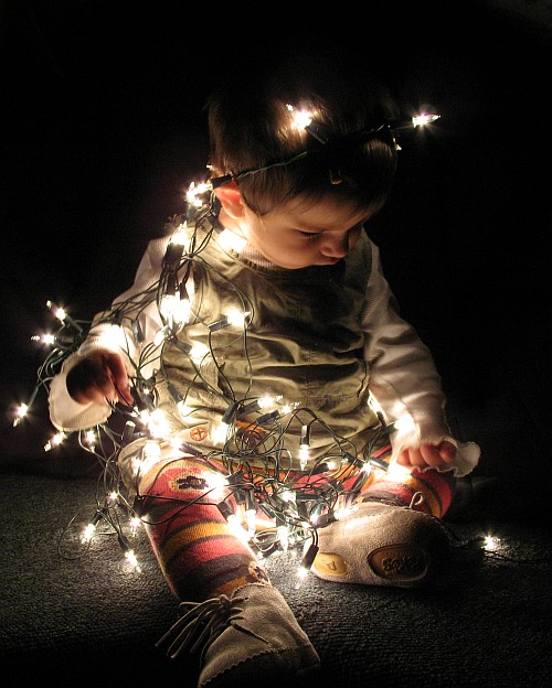 Alice, playing with some Christmas lights.