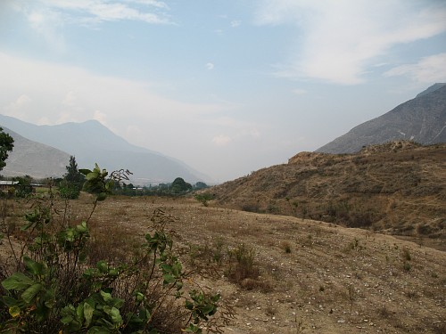 Barren fields with many stones. In the background the town of Acultzingo
