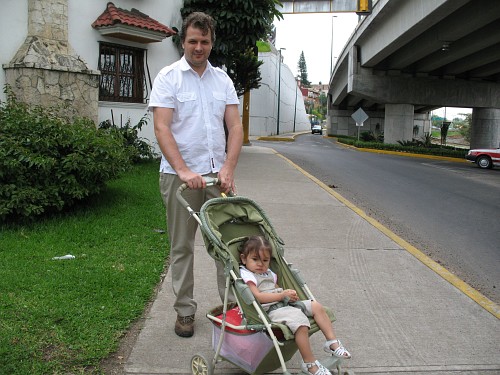 John posing with Alice in her stroller.