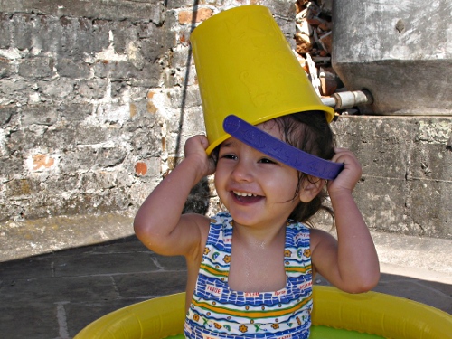Alice with a bucket on her head, smiling.