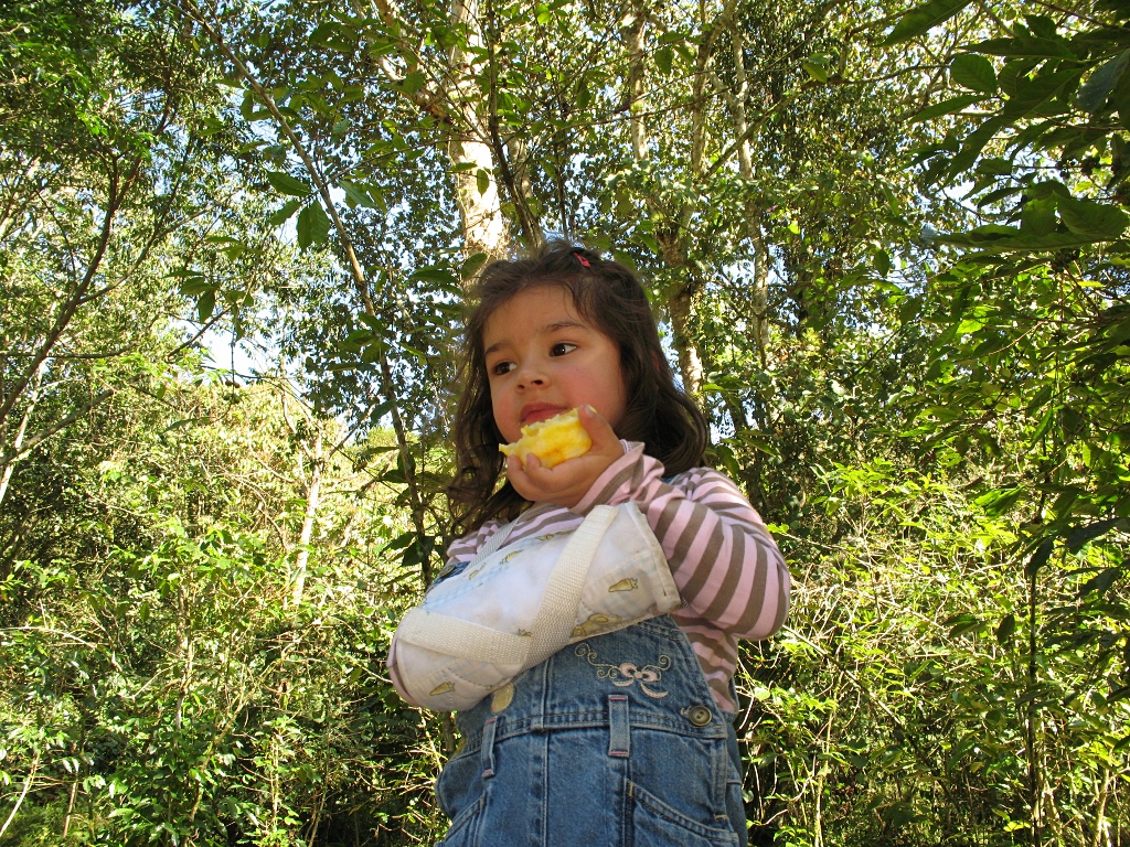 Alice eating an orange standing.