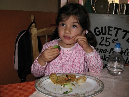 Alice eating tacos al pastore at Taqueria "Taz"